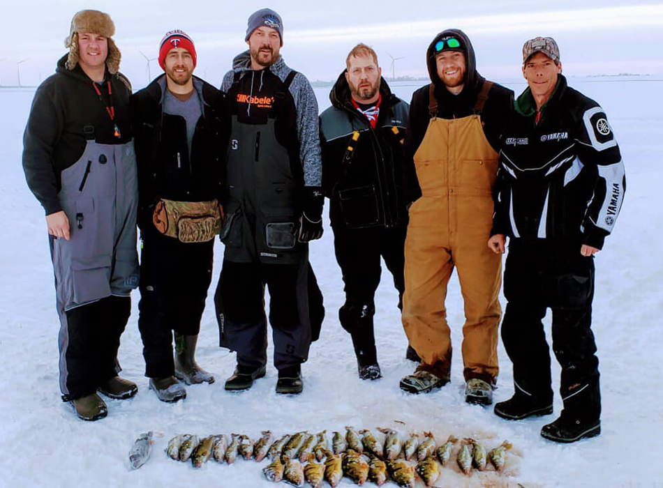 people standing with fish caught ice fishing